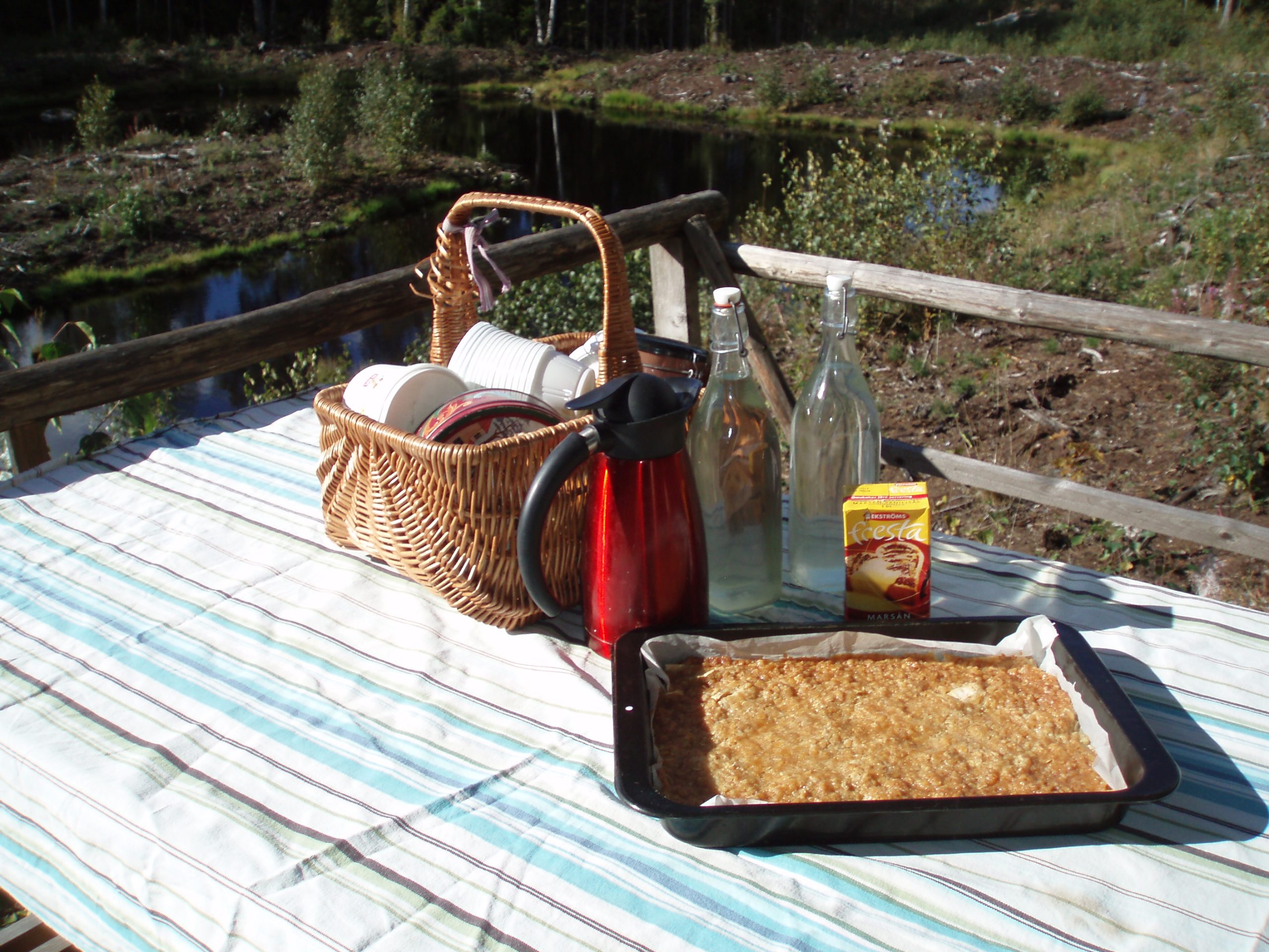 Här serveras havreäppelkaka med vaniljsås, citronsaft och kaffe i skogen.